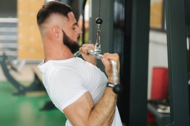 Genç bir atlet spor salonunda antrenman yaptı. Erkek sırt ve göğüs kasları trenler