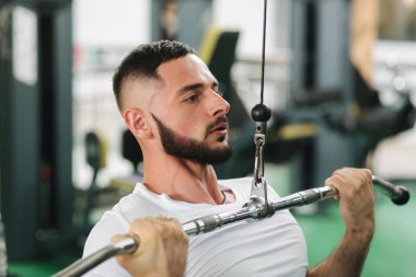 Genç bir atlet spor salonunda antrenman yaptı. Erkek sırt ve göğüs kasları trenler