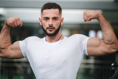 Genç atlet spor salonu zemin üzerine fotoğrafçılık için bir gövde ile poz. Vücut geliştirmeci, atlet pompalanır kaslar ile