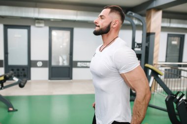 Adam spor salonunda elastik rof eğitim kullanın. Beyaz t-shirt trenler içinde Adam