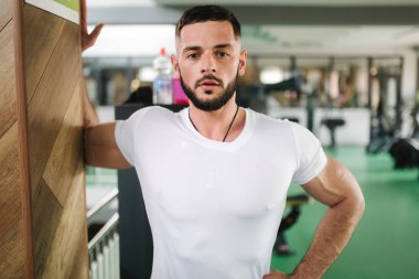 Adam spor salonunda ısınır. Yakışıklı sakallı adam trenler