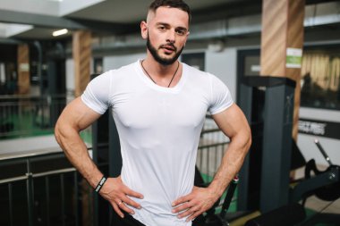 Genç atlet spor salonu zemin üzerine fotoğrafçılık için bir gövde ile poz. Vücut geliştirmeci, atlet pompalanır kaslar ile