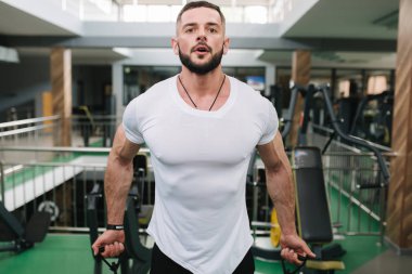 Adam spor salonunda elastik rof eğitim kullanın. Beyaz t-shirt trenler içinde Adam
