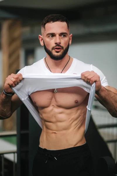 Νέος αθλητής που ποζάρει με κορμό για φωτογραφία στο γυμναστήριο. Bodybuilder, αθλητής με αντληθεί μύες, το στήθος και τη διάσωση του βραχίονα. Άνθρωπος εμφάνιση κοιλιακοί μύες — Φωτογραφία Αρχείου