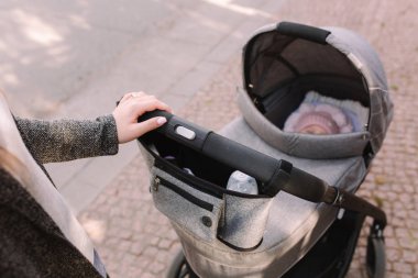 Anne dışarıda yeni doğmuş bir bebekle geziniyor. Annelerin elleri. Birinci kişi görünümü