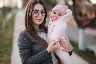 Küçük bebeği olan genç anne. Annem bebeği elinde tutur. Mutlu aile