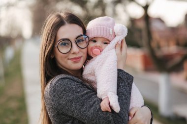 Anne ve onun küçük kız portresi. Güzel anne ve sevimli bebek. Anne kızı HUD. Bebek fıstık ch renkli şapka ve meme oyuncak giyinmiş