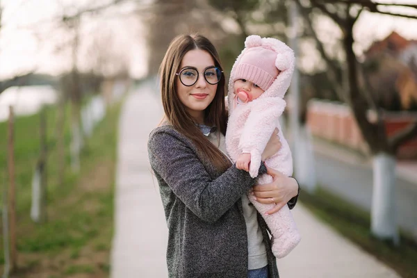 Mladá matka s malým dítětem. Máma drží dítě na rukou. Šťastná rodina — Stock fotografie