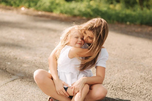 O familie iubitoare fericită. Mama şi fiica ei se joacă şi se îmbrăţişează. alee de copaci mari. aproape de vedere — Fotografie, imagine de stoc