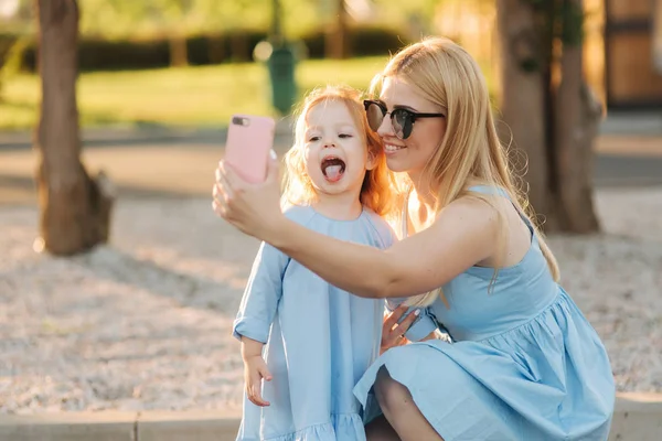Anya és kis lánya, hogy selfie a park — Stock Fotó