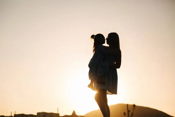 Silhouette von Mutter und kleiner Tochter. Sommersonnenuntergang — Stockfoto