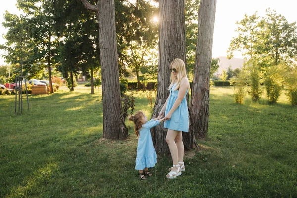 Mom and her daughter walking and holding hands — Stock Photo, Image