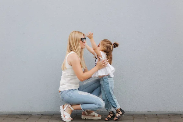 Schöne mothe mit ihrer Tochter. blonde Haare weiblich. grauer Hintergrund. beste Freunde — Stockfoto