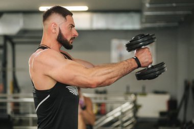 Spor salonunda Bearden vücut geliştirmeci. Siyah t-shirt güçlü adam