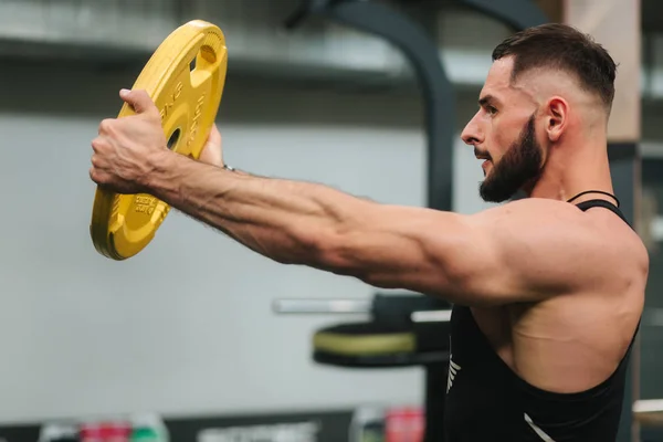 Culturista barbuto in palestra. Uomo forte in t-shirt nera — Foto Stock