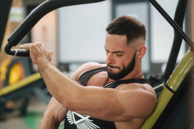 Genç bir atlet spor salonunda eğitiyor. Vücut geliştirmeci göğüs muscules trenler