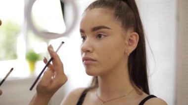 Güzellik stüdyosunda makyaj sanatçısı çalışması. Profesyonel tarafından başvuran kadın Master makyaj. Güzel makyaj sanatçı çiller ile Redhead modeli için bir makyaj yapmak. O bir palet kullanmak