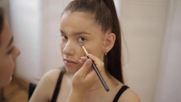 Model have a makeup by makeup artist in beauty salon. First person view. Redhead model with freckles. Close up of models face with make up — Stock Video