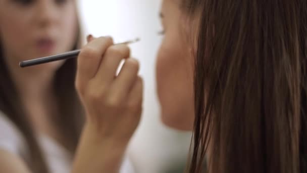 Макияж делает профессиональный макияж из молодой рыжей женщины с веснушками — стоковое видео