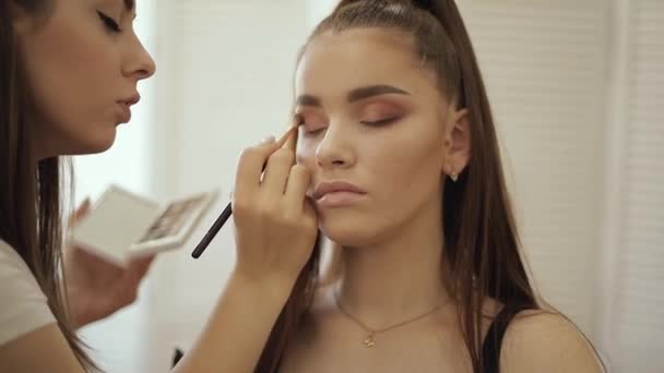 Makeup artist past oogschaduw, perfecte avond make-up toe. Schoonheid Redhead meisje met perfecte huid en sproeten — Stockvideo