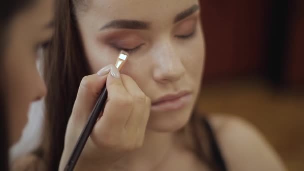 Maquillaje artista aplica sombra de ojos, maquillaje de noche perfecto. Chica pelirroja de belleza con la piel perfecta y pecas — Vídeos de Stock