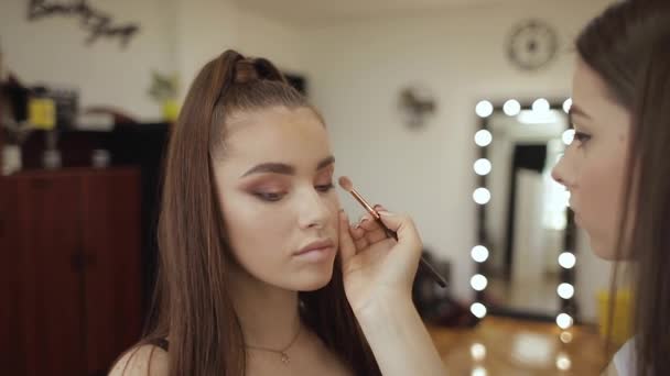 Modell haben ein Make-up von Visagistin im Schönheitssalon. Ich-Perspektive. Rotschopf-Modell mit Sommersprossen. Nahaufnahme von Models Gesicht mit Make-up — Stockvideo