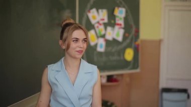 Bayan öğretmen okul masasında mezgit kazıyor. Genç öğretmen.