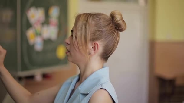 Insegnante di sesso femminile che sfrutta le cose sulla scrivania della scuola. Giovane insegnante — Video Stock