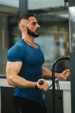 Genç bir atlet spor salonunda eğitiyor. Trians pazı muscules
