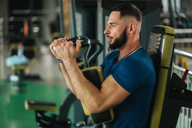 Genç bir atlet spor salonunda eğitiyor. Vücut geliştirmeci göğüs muscules trenler