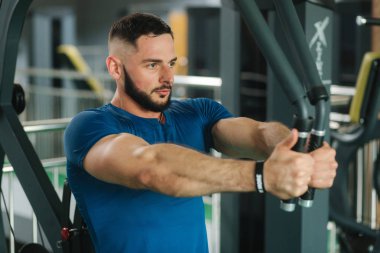 Genç bir atlet spor salonunda eğitiyor. Vücut geliştirmeci göğüs muscules trenler