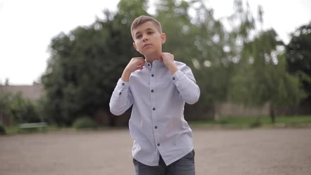 学校の裏庭でシャツを着た少年幸せな子供 — ストック動画