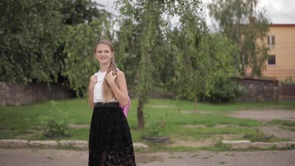Νεαρή κοπέλα περπατά στο πάρκο με σακίδιο πλάτης — Αρχείο Βίντεο