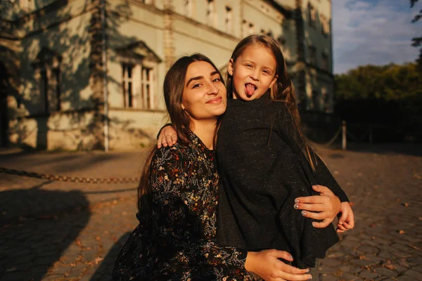 Sonbaharda parkta yürürken iki mutlu kız kardeşi. Genç kız kardeşi ile küçük kız kardeşi — Stok fotoğraf