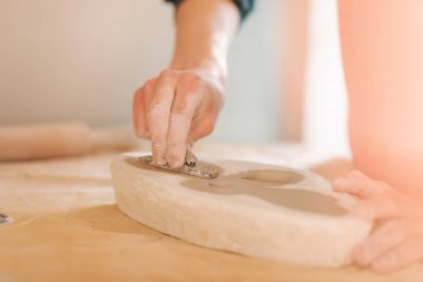 Kil kelebek damga. Seramik ürün. Masanın üzerinde adam el