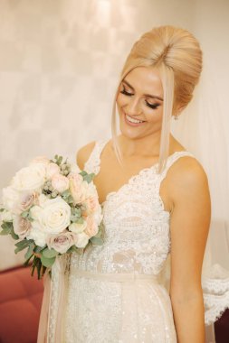 Muhteşem gelin evde portresi. Buket ile sevimli kadın. Sabah güzel gelinin. Düğün günü