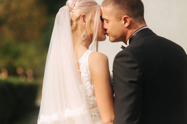 Parkta yürüyen yeni evliler arka görünümü. zarif gelin ve yakışıklı damat