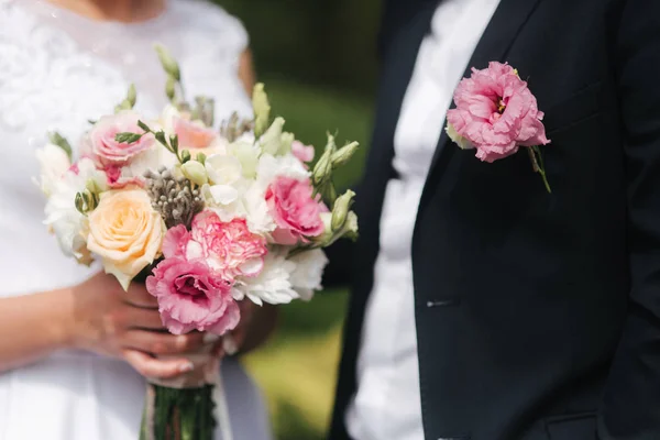 Buquê de casamento em mãos de noivas. Close-up vista de casais mãos segurando buquê de casamento. Flores — Fotografia de Stock