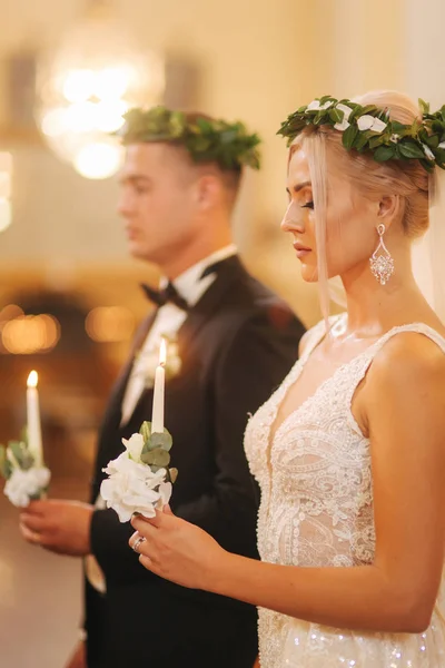 Belo casal na igreja. Os recém-casados juram um ao outro amar para sempre. Noiva feliz e noivo — Fotografia de Stock