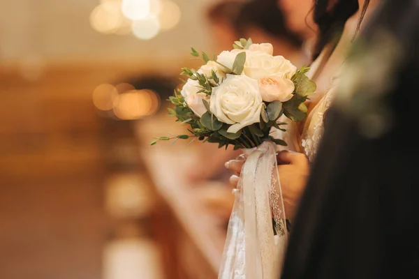 Elemento de decoração na igreja. Buquê de casamento em mãos — Fotografia de Stock