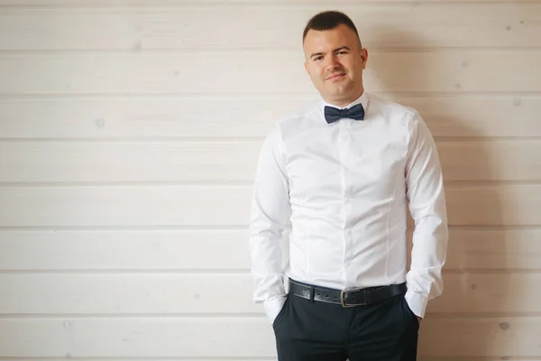 Schöner Bräutigam in weißem Hemd und blauer Krawattenfliege. Bräutigam an seinem Hochzeitstag gekleidet — Stockfoto