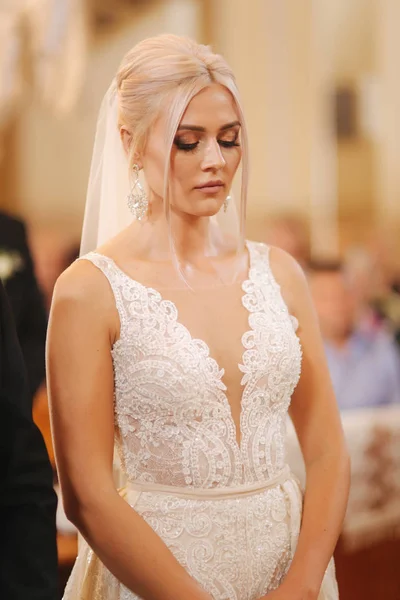 Gyönyörű szőke haj menyasszony a templomban — Stock Fotó