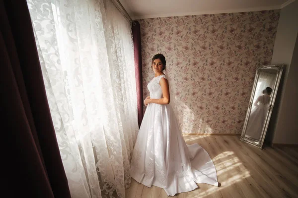 Charmante mariée debout devant la fenêtre. Une fille se tient près de la fenêtre de sa chambre. Noir et blanc. Silhouette — Photo