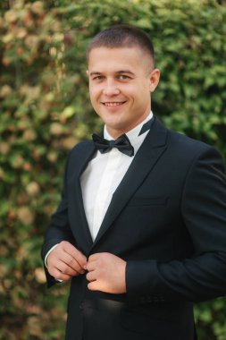 Parkta yürüyen genç adam. Siyah elbiseli yakışıklı damat