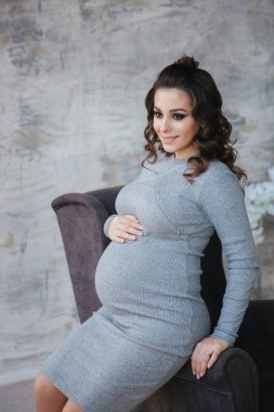 Güzel Abiye şık hamile modelinde de koltuğa otur. Arka yatak odası