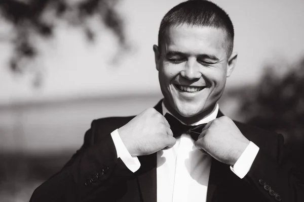 Schöner Bräutigam trug eine Krawattenfliege. Hochzeitstag. Mann draußen. Junger Mann lächelt — Stockfoto