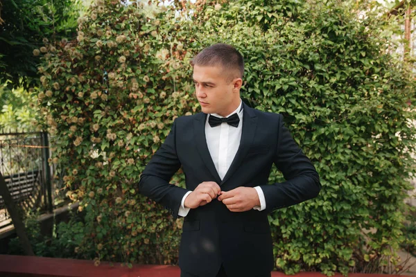 Un joven caminando por el parque. novio guapo en traje negro — Foto de Stock