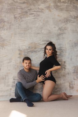 Mutlu bir adam onun handr onun hamile eşi karnına koydu. Genç aile Studio. Bir bebek için beklemek birleştirmek