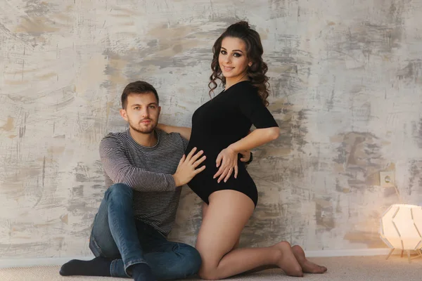 Glücklicher Mann legte seine Hand auf den Bauch seiner schwangeren Frau. junge Familie im Studio. Paar wartet auf ein Baby — Stockfoto