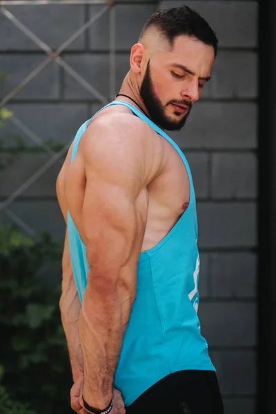 Bonito fisiculturista em azul singlet posando fora. Barba homens antes do treinamento — Fotografia de Stock